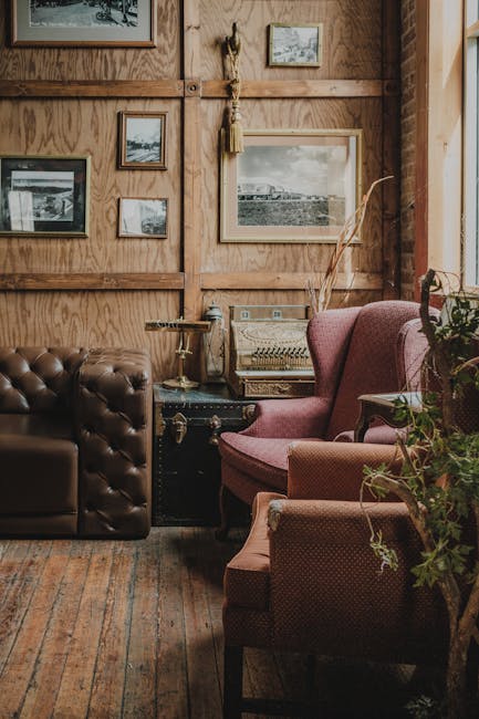 Warm vintage living room with armchairs, wooden floor, and classic decor.
